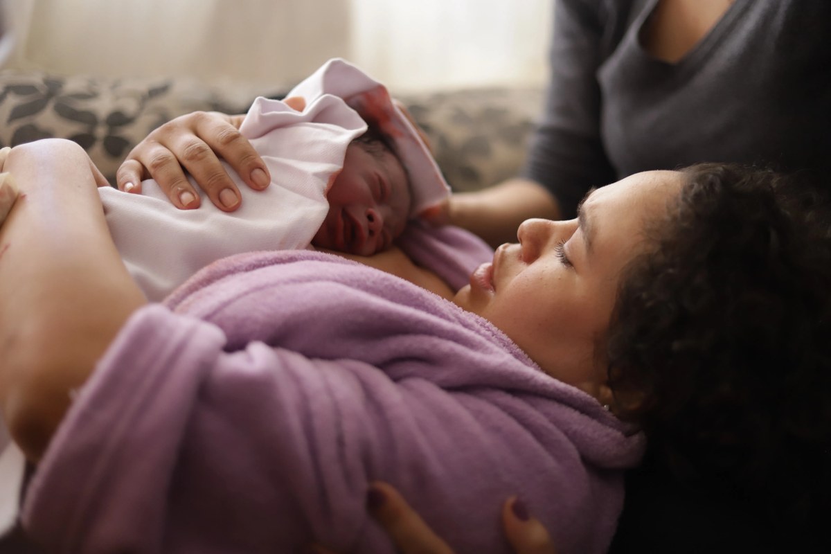 Mãe com bebê recém-nascido no colo